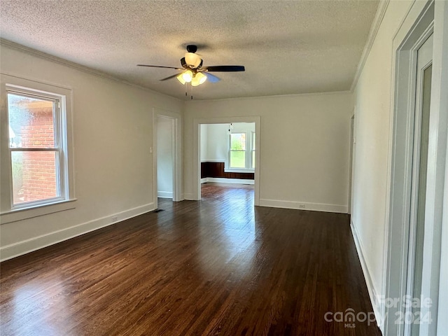 empty room with crown molding, ceiling fan, dark wood-type flooring, and a textured ceiling