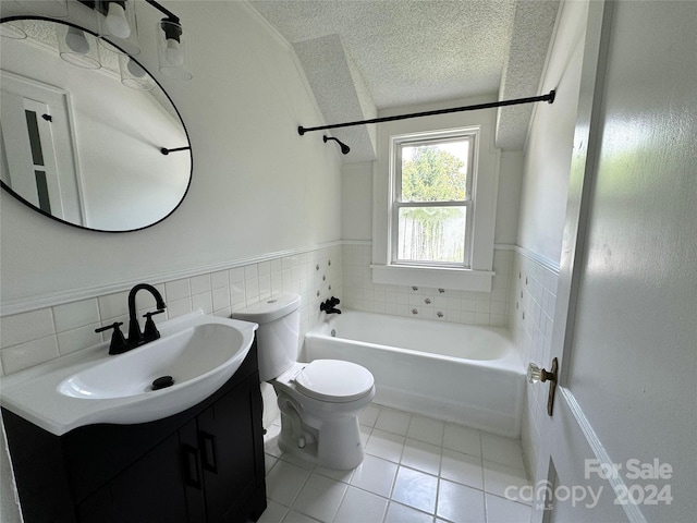 full bathroom featuring tile patterned floors, a textured ceiling, toilet, vanity, and tile walls