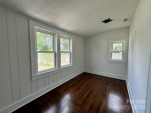 unfurnished room with dark hardwood / wood-style floors and a textured ceiling