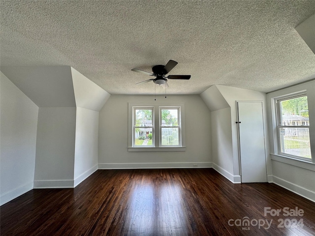 bonus room featuring a healthy amount of sunlight, ceiling fan, dark wood-type flooring, and lofted ceiling