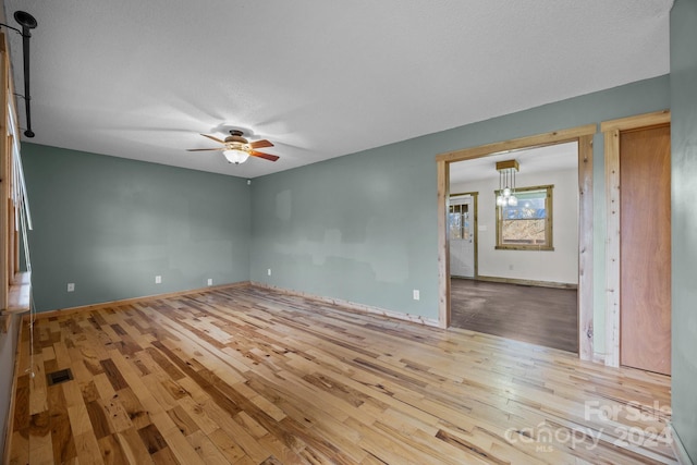 spare room featuring a textured ceiling, light wood-type flooring, and ceiling fan