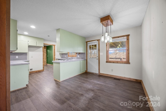 kitchen featuring pendant lighting, dark hardwood / wood-style floors, kitchen peninsula, and a textured ceiling