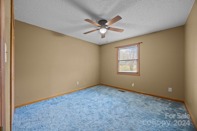 carpeted empty room with a textured ceiling and ceiling fan