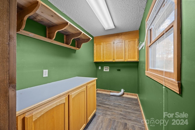 clothes washing area featuring a textured ceiling, washer hookup, and dark hardwood / wood-style floors