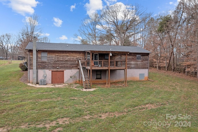 rear view of property with central air condition unit, a lawn, and a wooden deck