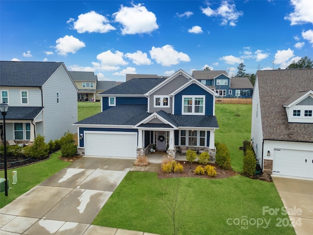 view of front of house featuring a front yard, a garage, and covered porch