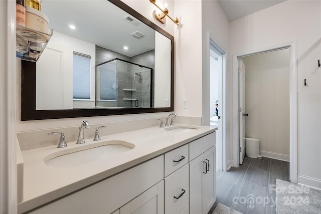 bathroom with vanity and a shower with door