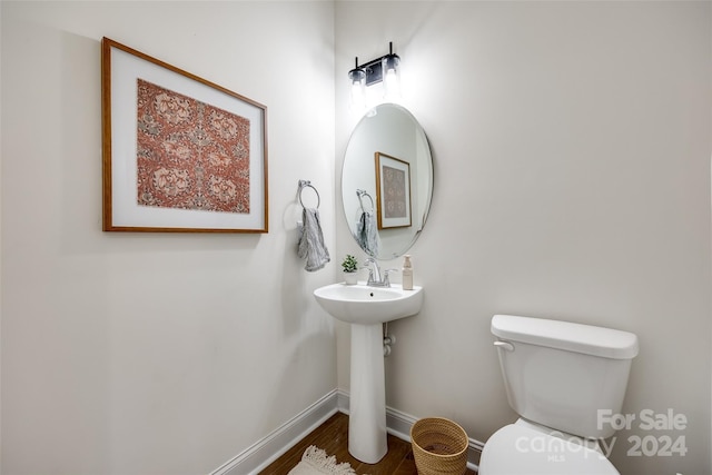 bathroom with hardwood / wood-style flooring, toilet, and sink