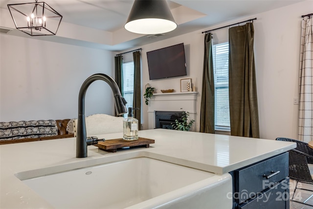 kitchen with pendant lighting, a notable chandelier, a healthy amount of sunlight, and sink