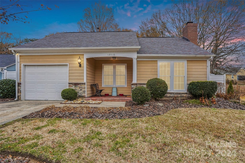 view of front of house featuring a garage and a lawn