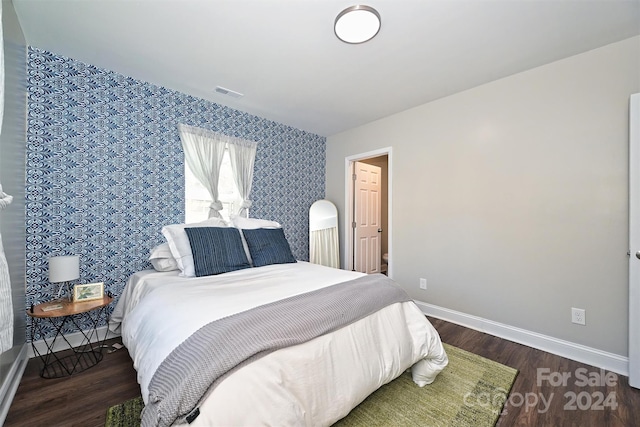 bedroom with dark hardwood / wood-style floors