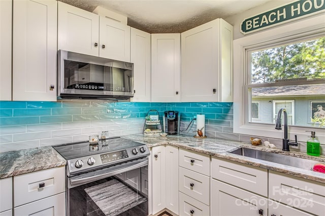 kitchen featuring white cabinetry, sink, a textured ceiling, and appliances with stainless steel finishes