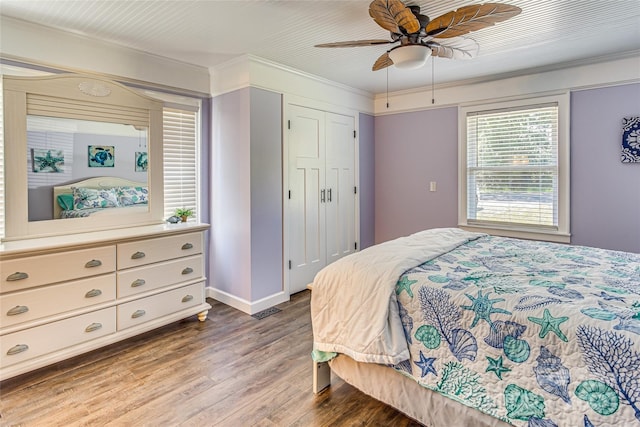 bedroom featuring hardwood / wood-style floors, ceiling fan, ornamental molding, and a closet