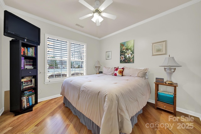 bedroom with hardwood / wood-style flooring, ceiling fan, and crown molding