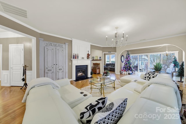 living room featuring a fireplace, a chandelier, and light wood-type flooring