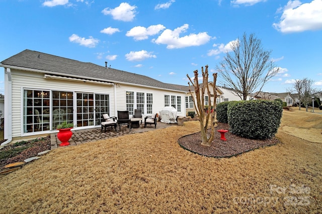 rear view of property with a lawn and a patio area