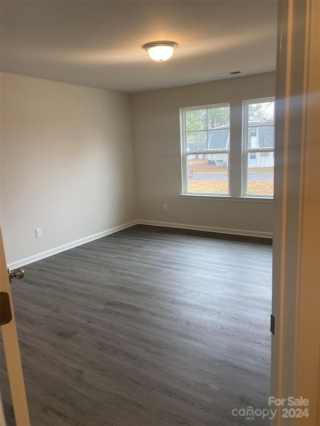 unfurnished room featuring dark wood-type flooring