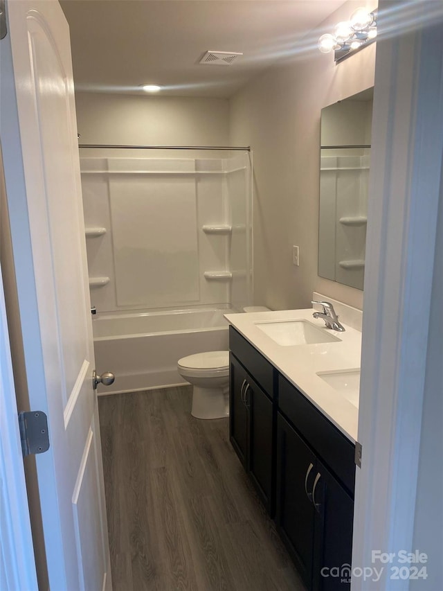 full bathroom with bathing tub / shower combination, toilet, vanity, and hardwood / wood-style flooring