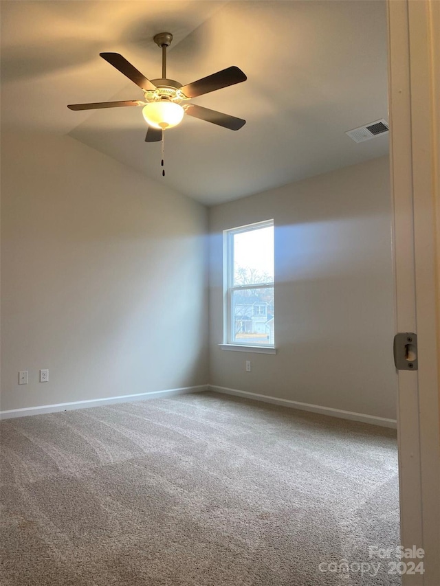 spare room featuring carpet, ceiling fan, and lofted ceiling