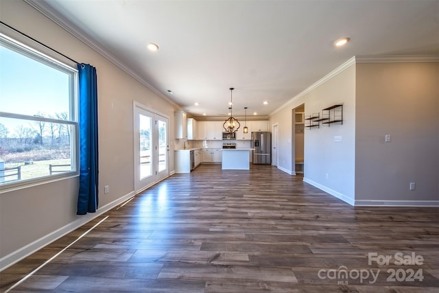 unfurnished living room featuring crown molding, plenty of natural light, and dark hardwood / wood-style floors