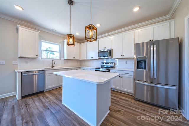 kitchen featuring stainless steel appliances, sink, pendant lighting, dark hardwood / wood-style floors, and white cabinetry