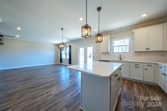 kitchen featuring dark hardwood / wood-style flooring, white cabinetry, a kitchen island, and sink