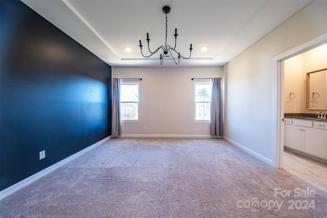 carpeted empty room with a raised ceiling and sink