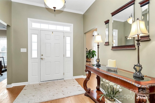 foyer entrance with crown molding and hardwood / wood-style floors