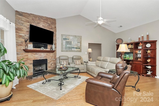 living room featuring a fireplace, light wood-type flooring, ceiling fan, and lofted ceiling