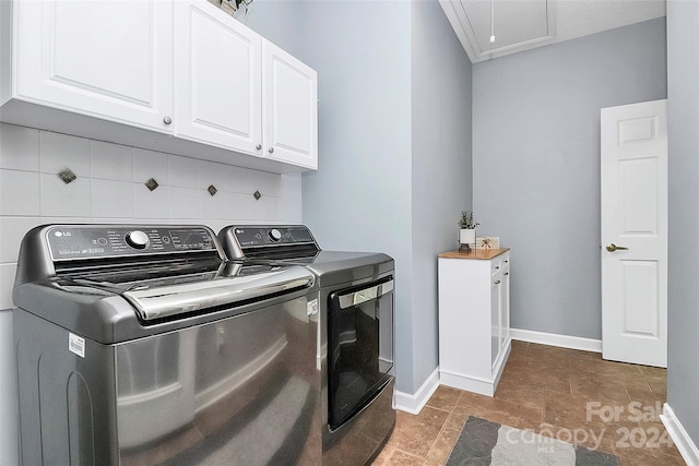 laundry room with washing machine and dryer and cabinets