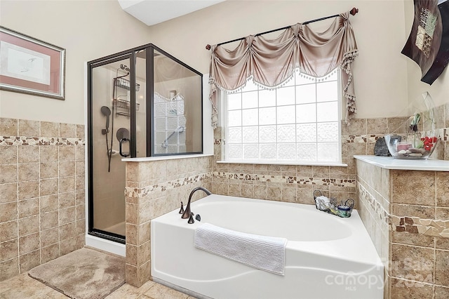 bathroom featuring separate shower and tub, tile patterned flooring, and tile walls