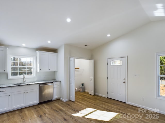 kitchen with lofted ceiling, dishwasher, sink, light hardwood / wood-style flooring, and white cabinets