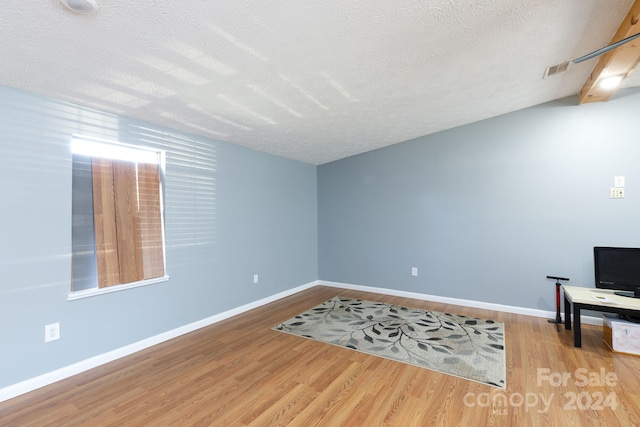 living room featuring wood-type flooring and a textured ceiling