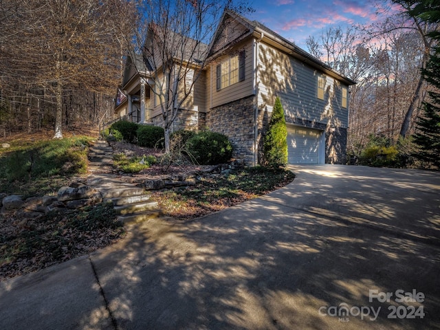 property exterior at dusk featuring a garage