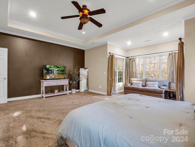 bedroom featuring ceiling fan, carpet floors, ornamental molding, and a tray ceiling