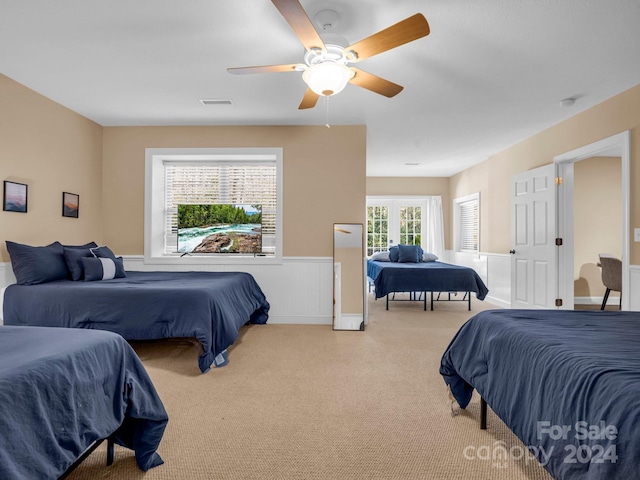 bedroom with ceiling fan, light carpet, and french doors