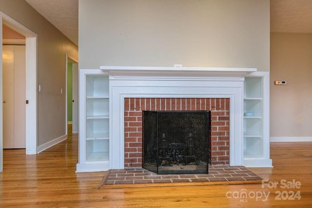 room details with a fireplace, a textured ceiling, and hardwood / wood-style flooring