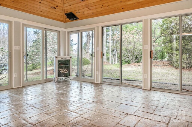 unfurnished sunroom featuring a wealth of natural light, a fireplace, wooden ceiling, and vaulted ceiling