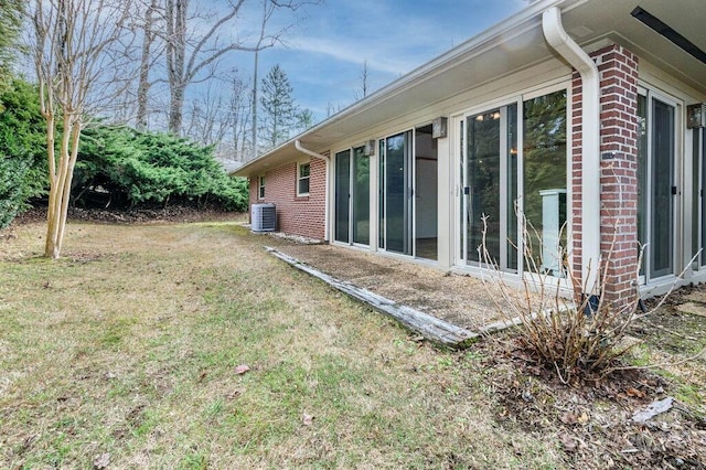 view of side of home with cooling unit and a lawn