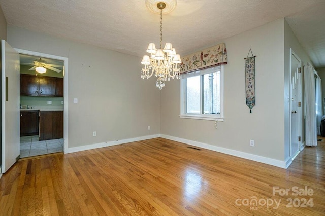 empty room with a textured ceiling and light wood-type flooring