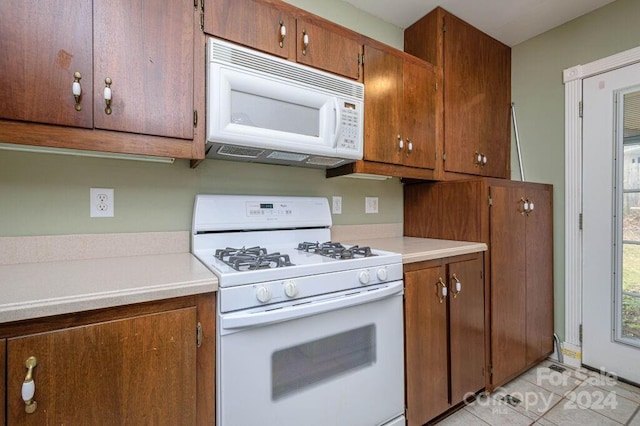 kitchen with white appliances and light tile patterned floors