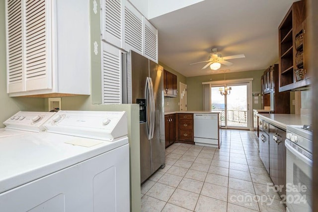 clothes washing area featuring light tile patterned floors, ceiling fan with notable chandelier, and washing machine and clothes dryer