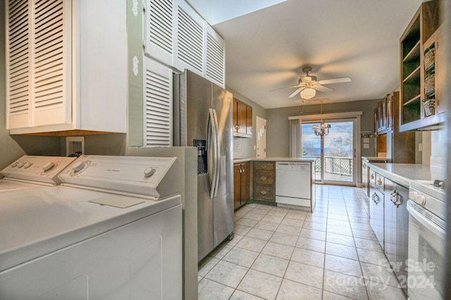 washroom with ceiling fan with notable chandelier, light tile patterned floors, and washing machine and clothes dryer