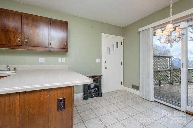 kitchen featuring a chandelier, pendant lighting, kitchen peninsula, and light tile patterned floors