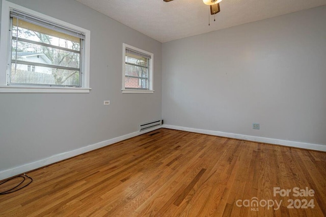 unfurnished room with a textured ceiling, light wood-type flooring, a baseboard radiator, and ceiling fan