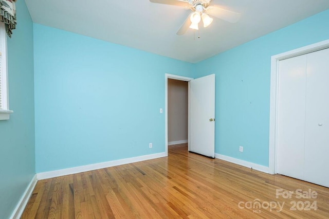 unfurnished bedroom featuring light wood-type flooring, a closet, and ceiling fan