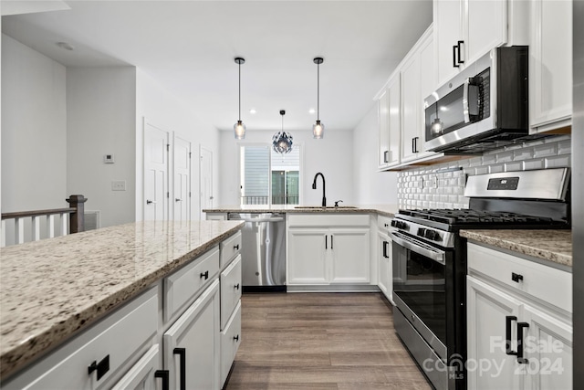 kitchen with white cabinetry, sink, hardwood / wood-style floors, and appliances with stainless steel finishes