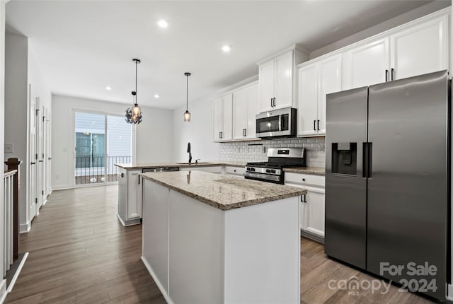 kitchen with white cabinets, decorative light fixtures, dark wood-type flooring, and appliances with stainless steel finishes