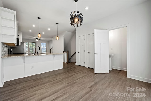 kitchen featuring white cabinetry, ceiling fan, dark wood-type flooring, kitchen peninsula, and decorative light fixtures