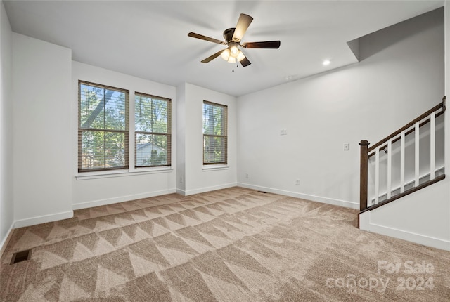 empty room with light colored carpet and ceiling fan